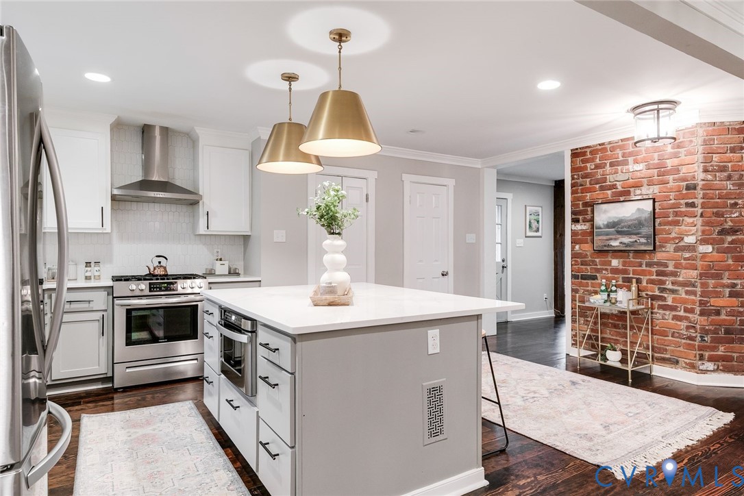 2831 Earlswood Road Midlothian, VA 23113 - Photo 15 of 47 a kitchen with a stove a sink a kitchen island with wooden cabinets and floor