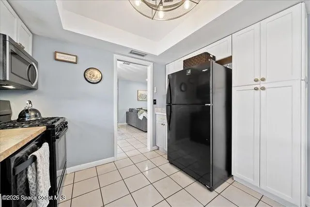 a kitchen with a refrigerator and a stove top oven
