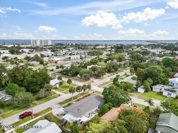 an aerial view of residential houses with outdoor space and trees