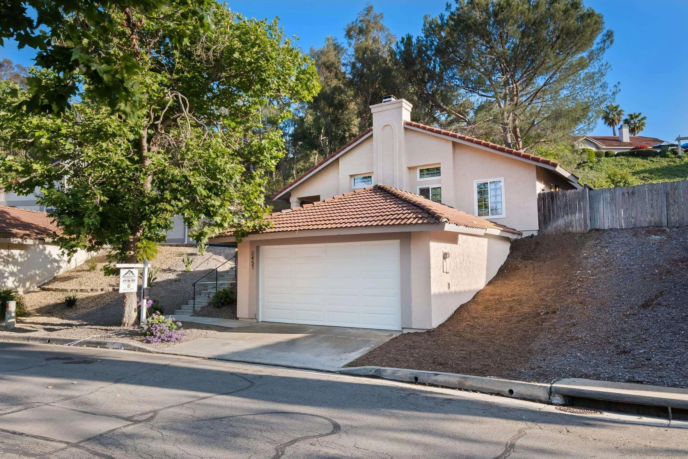 a view of a white house with a street