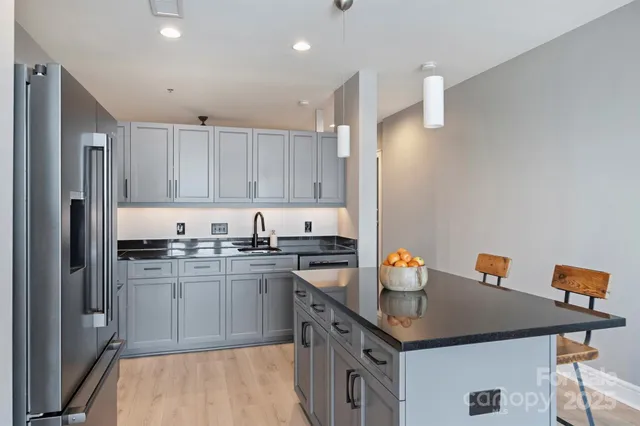 a kitchen with stainless steel appliances granite countertop a sink stove and refrigerator