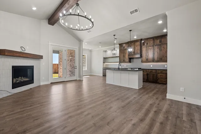 a view of kitchen with granite countertop stainless steel appliances and wooden floor