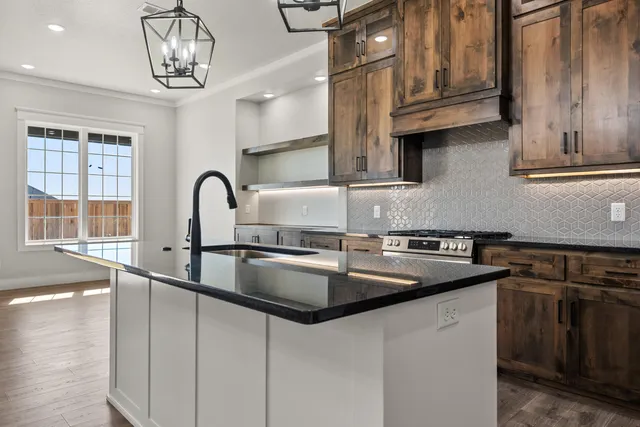 a kitchen with stainless steel appliances granite countertop a sink stove and cabinets