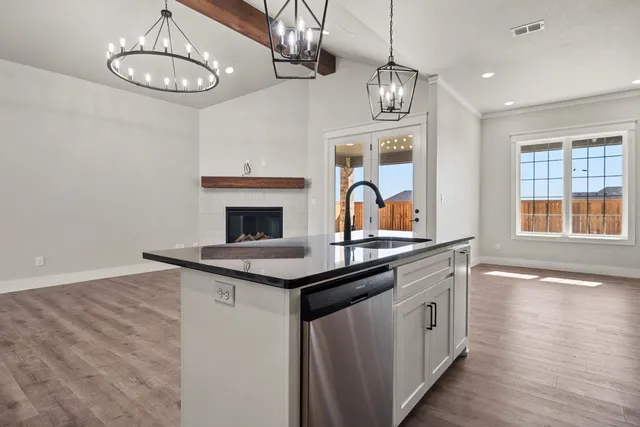 a kitchen with stainless steel appliances granite countertop a stove and a wooden floors