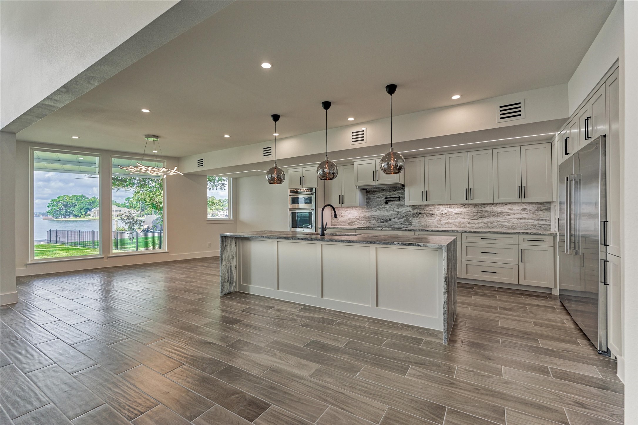 2811 Hemingway Drive Montgomery, TX 77356 - Photo 18 of 50 a kitchen with kitchen island granite countertop a sink cabinets and wooden floor