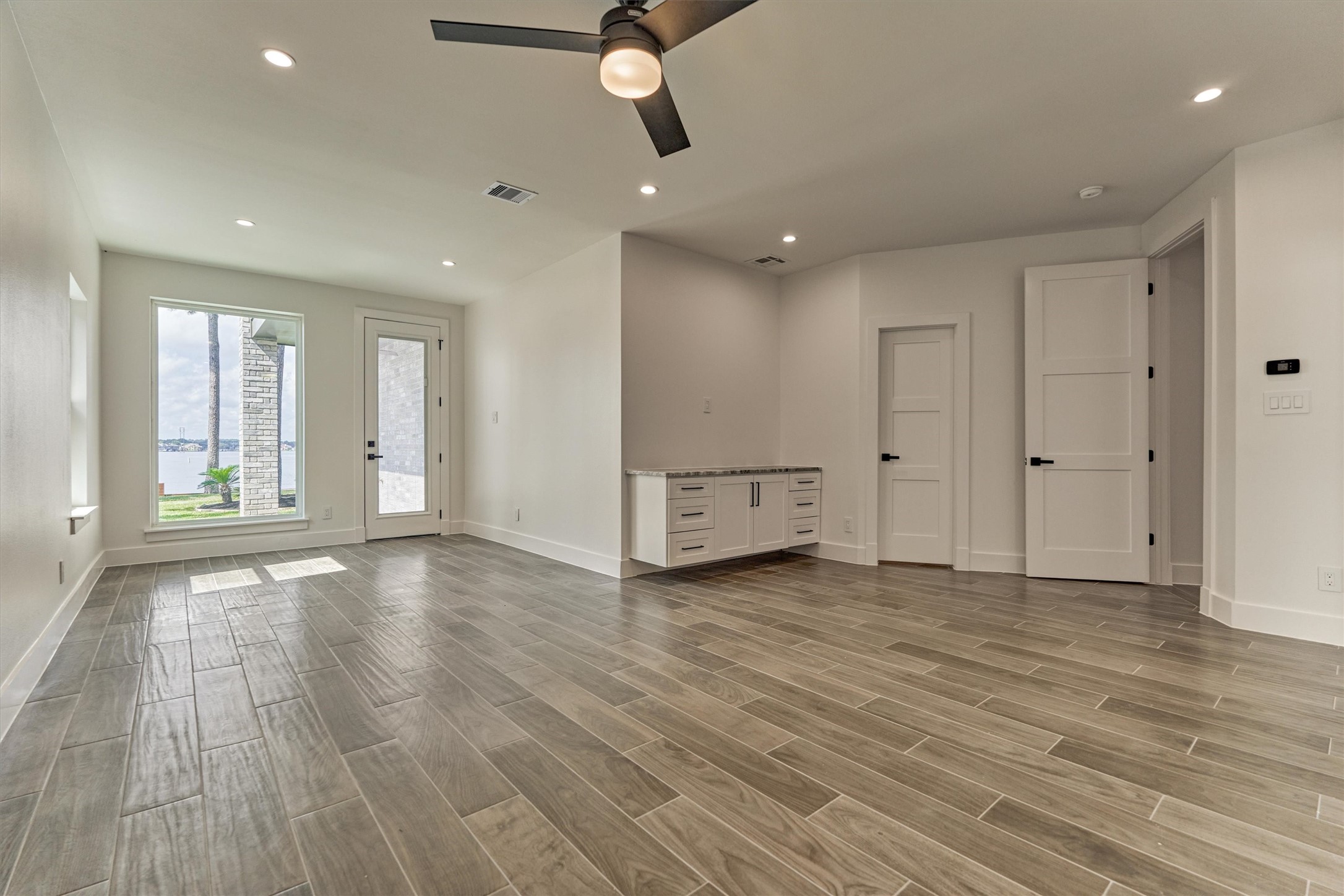 2811 Hemingway Drive Montgomery, TX 77356 - Photo 27 of 50 an empty room with wooden floor cabinet and windows