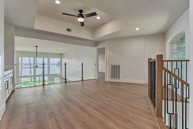 a view of an empty room with window and wooden floor