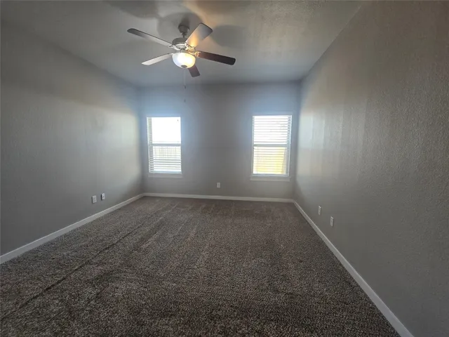 an empty room with a window and a fan