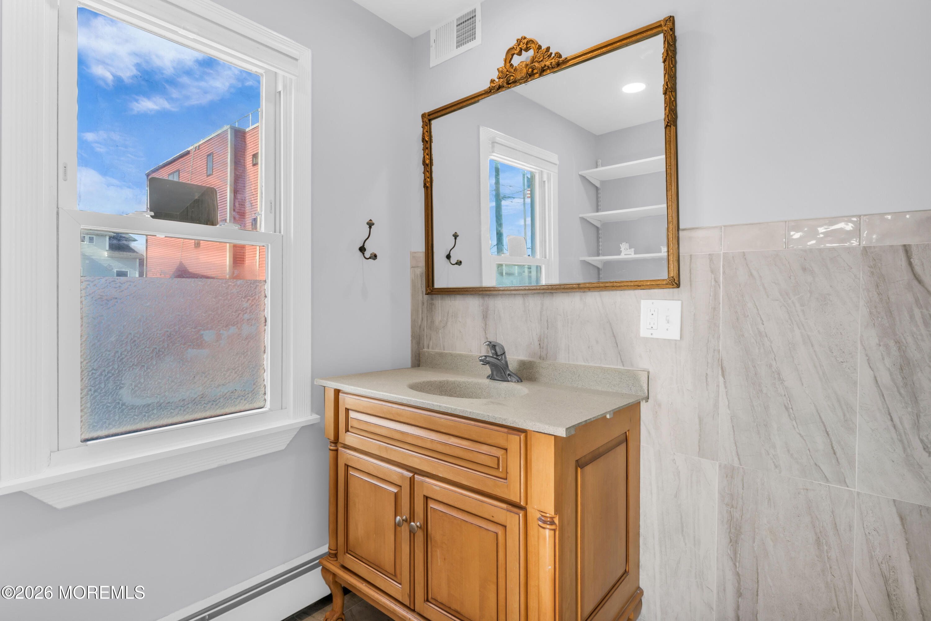 2 Bedle Place Highlands, NJ 07732 - Photo 11 of 25 a bathroom with a sink a vanity and a mirror