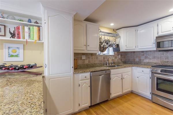 9 Joy Street, Unit 3 Boston, MA 02114 - Photo 3 of 16 a kitchen with cabinets a sink and a stove top oven