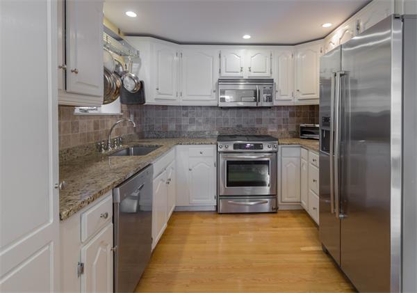 9 Joy Street, Unit 3 Boston, MA 02114 - Photo 4 of 16 a kitchen with kitchen island granite countertop a sink stainless steel appliances and cabinets