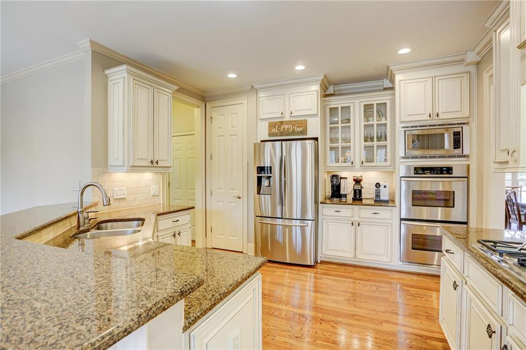 11015 Callington Court Suwanee, GA 30024 - Photo 19 of 87 a kitchen with stainless steel appliances granite countertop a sink refrigerator and cabinets