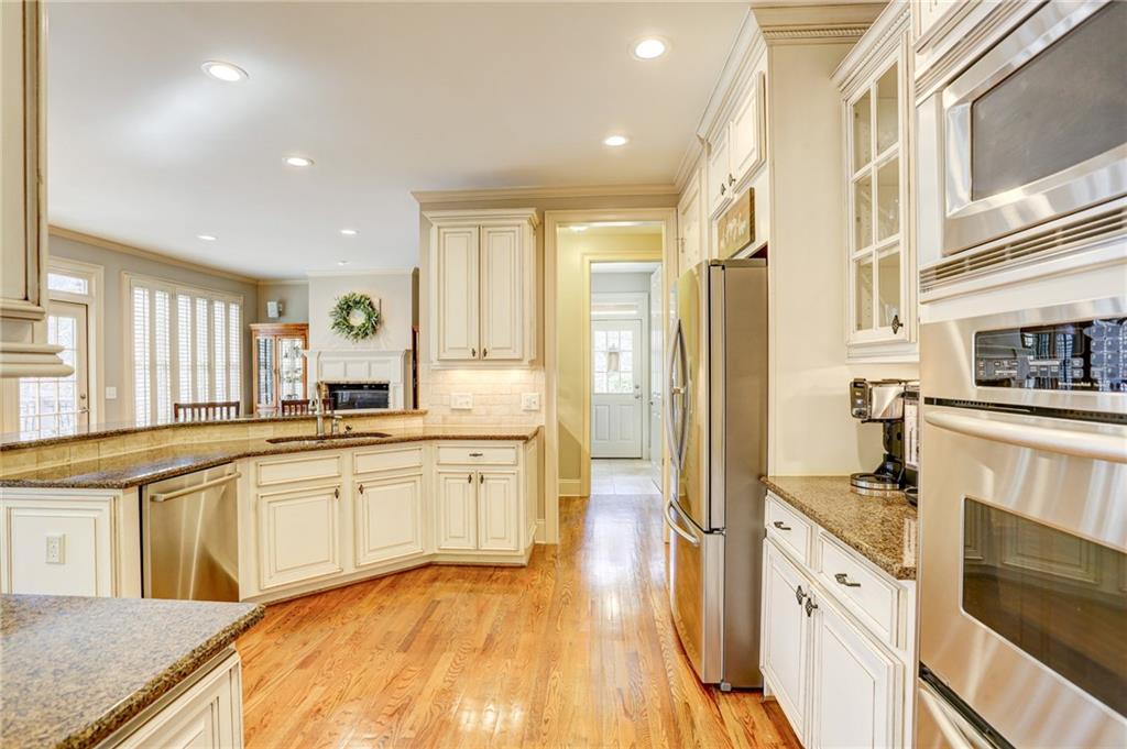 11015 Callington Court Suwanee, GA 30024 - Photo 22 of 87 a large kitchen with stainless steel appliances a large counter top a stove and a refrigerator