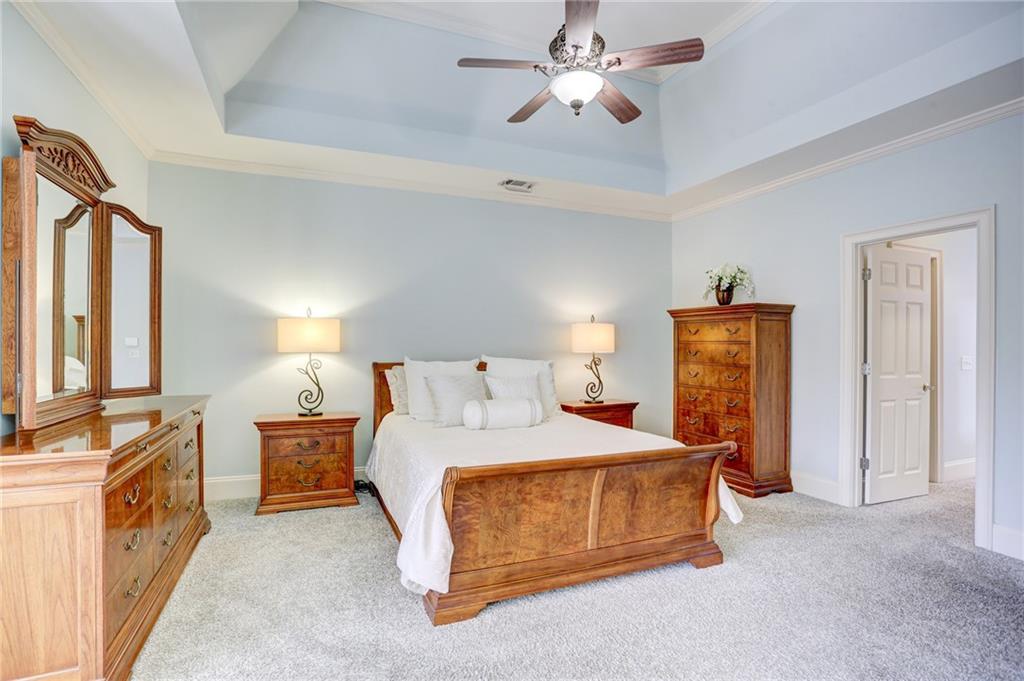 11015 Callington Court Suwanee, GA 30024 - Photo 43 of 87 a bedroom with a bed and a chandelier