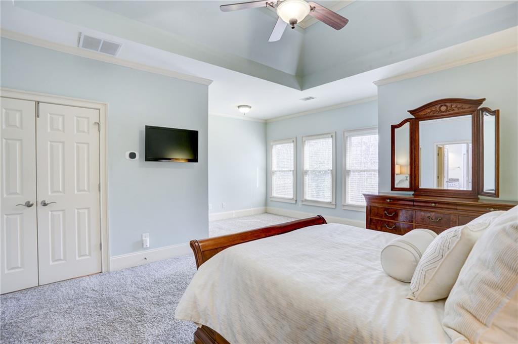 11015 Callington Court Suwanee, GA 30024 - Photo 45 of 87 a bedroom with a large bed and a flat tv screen
