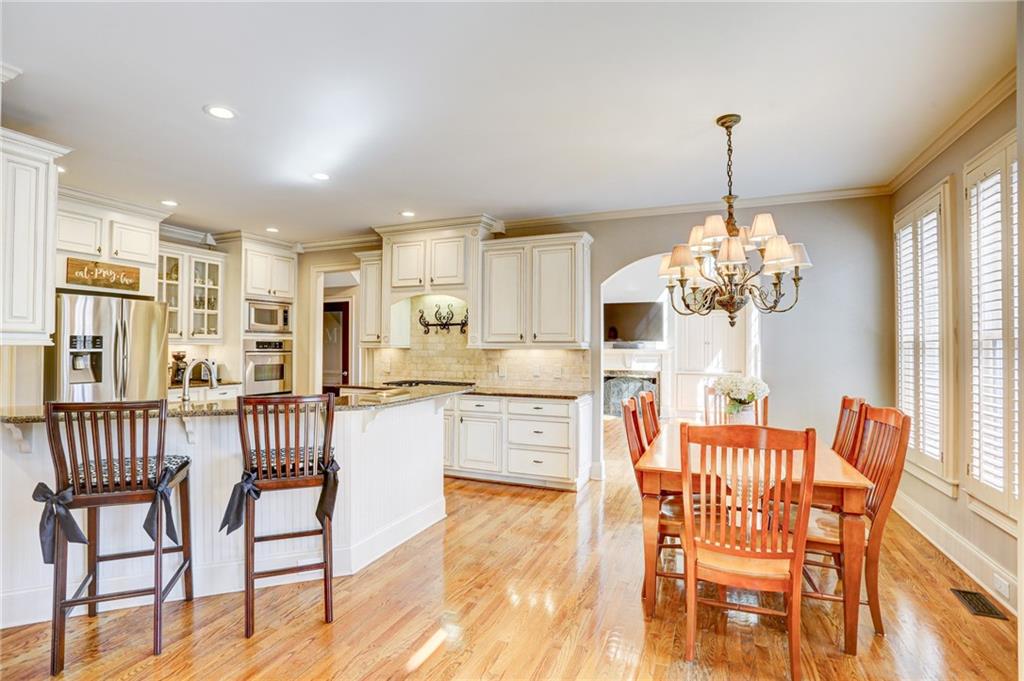 11015 Callington Court Suwanee, GA 30024 - Photo 5 of 87 a dining room with furniture a chandelier and wooden floor