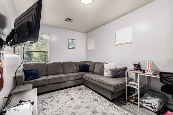 a living room with furniture a flat screen tv and a window