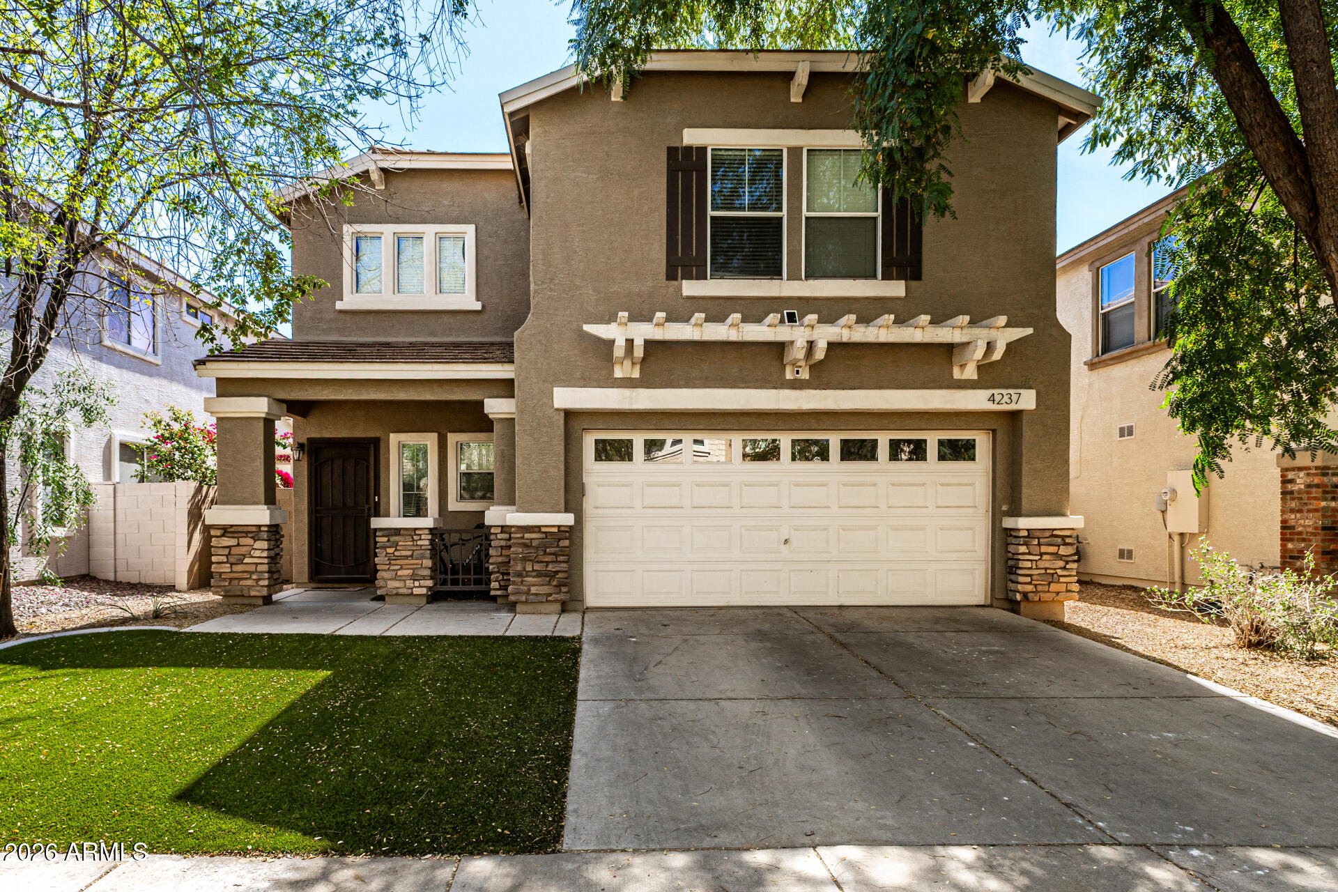 4237 East Orchid Lane Gilbert, AZ 85296 - Photo 2 of 33 a view of a white house with a large window and a yard with plants