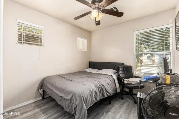 a bedroom with a bed and wooden floor