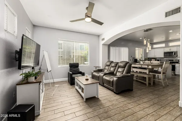 a living room with furniture kitchen view and a window