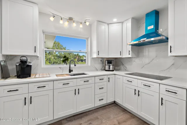 a kitchen with white cabinets and white appliances