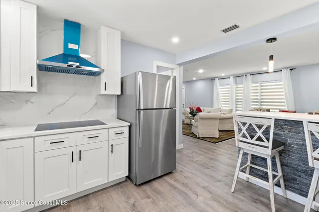 a kitchen with stainless steel appliances granite countertop a refrigerator and a stove top oven