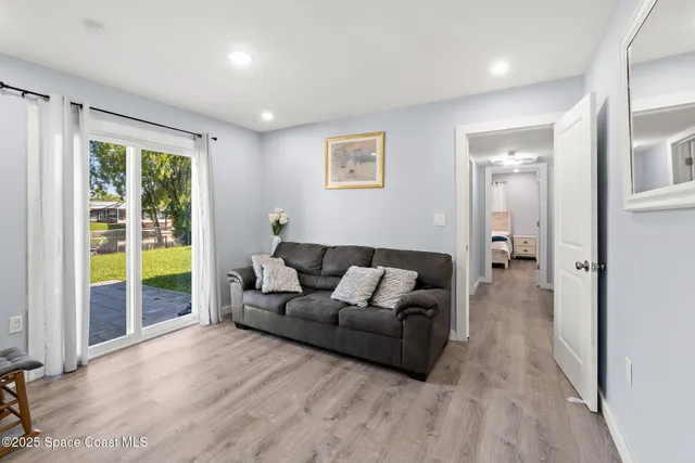 a living room with furniture and a floor to ceiling window