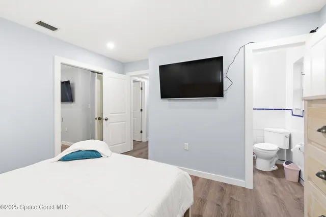 a bedroom with a bed and a flat screen tv