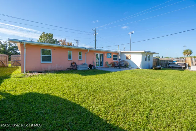 a view of a house with a yard and potted plants