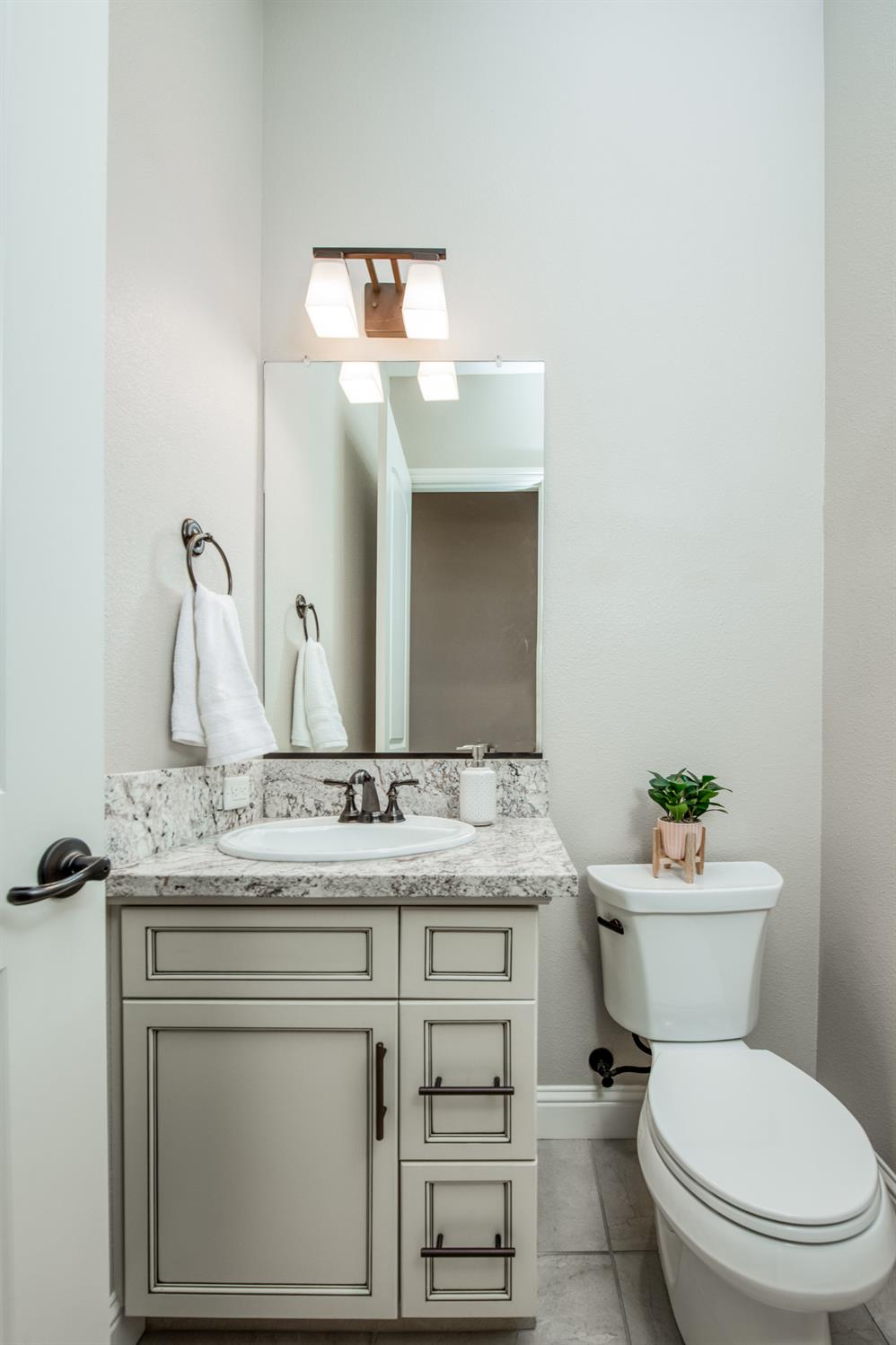 598 Crescent Lane Madera, CA 93636 - Photo 13 of 80 a bathroom with a granite countertop toilet sink and mirror