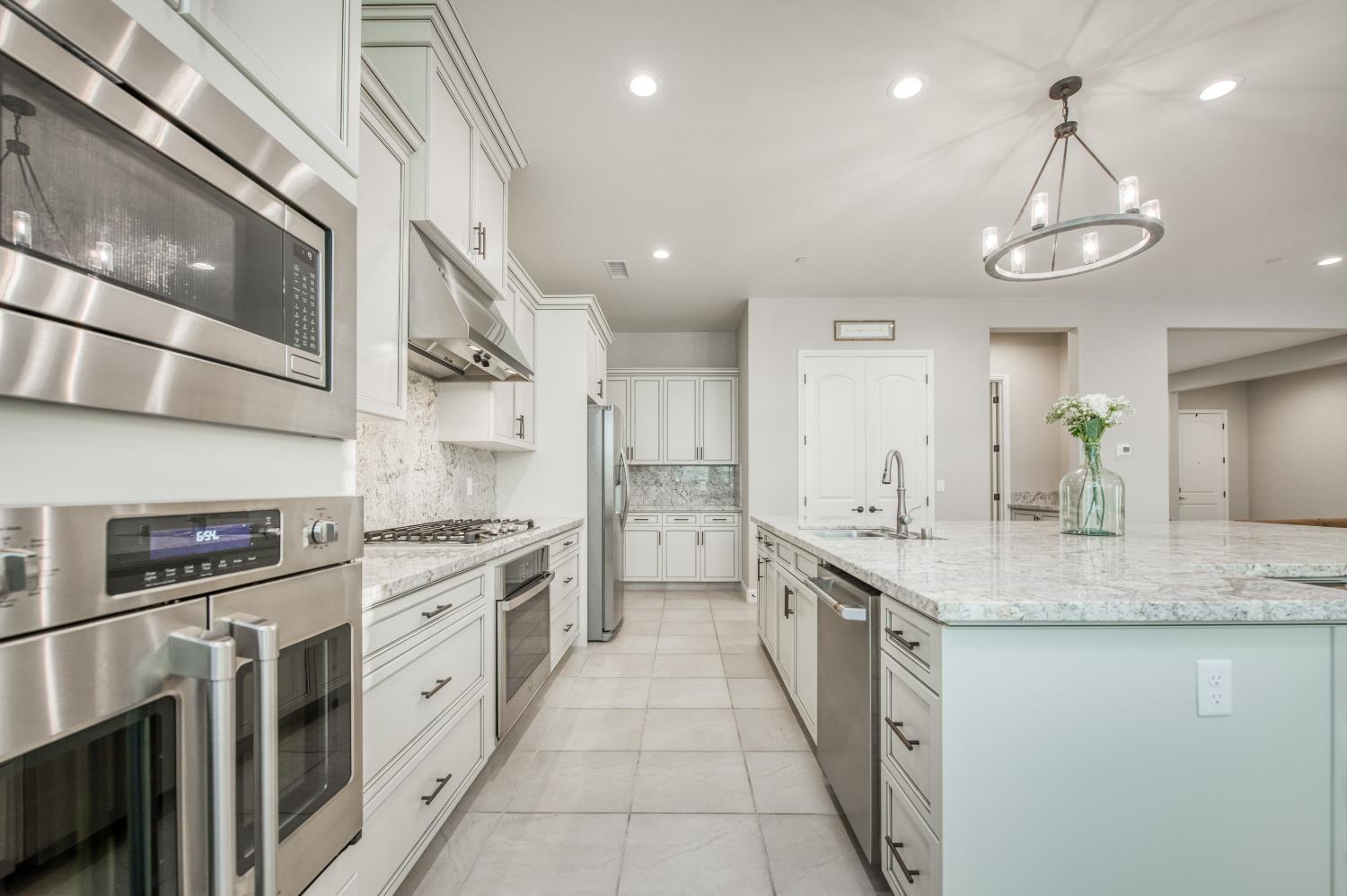 598 Crescent Lane Madera, CA 93636 - Photo 24 of 80 a large kitchen with stainless steel appliances granite countertop a sink and stove