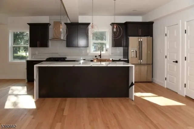 a kitchen with stainless steel appliances granite countertop a sink a stove a refrigerator and cabinets