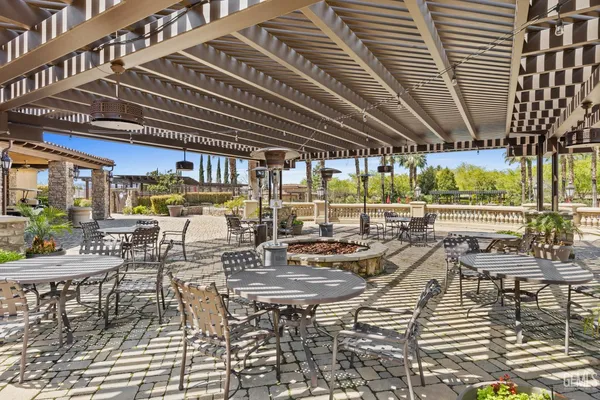 a kitchen with stainless steel appliances kitchen island granite countertop a stove a refrigerator a dining table and chairs with wooden floor