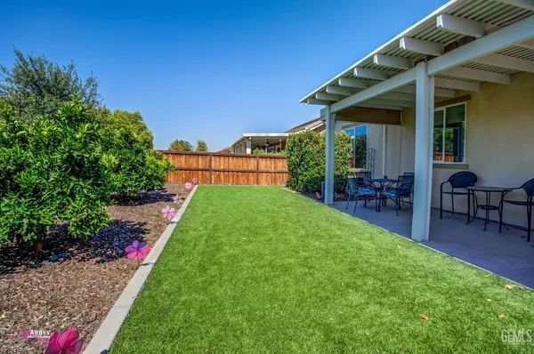 a view of a backyard with potted plants and a wooden fence