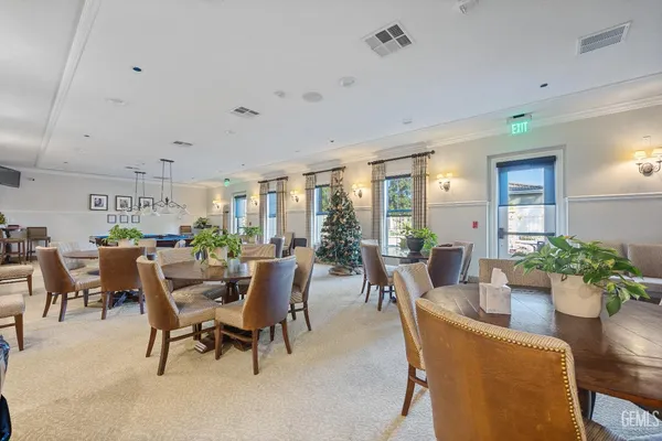 a view of a patio with table and chairs potted plants and floor to ceiling window