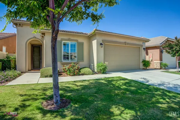 a front view of a house with a yard and palm trees