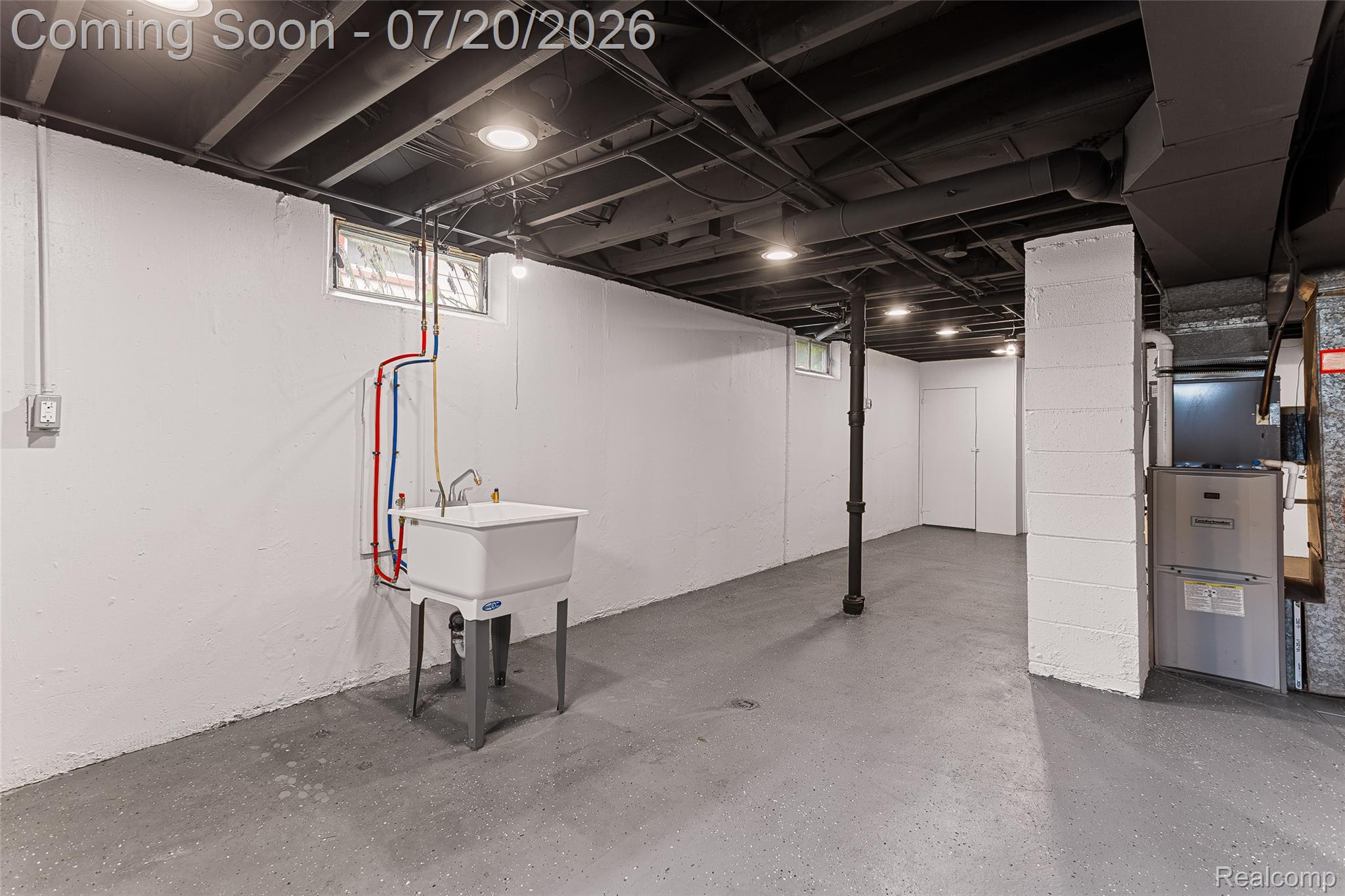 7884 Pardee Road Taylor, MI 48180 - Photo 18 of 23 Spacious utility area featuring a laundry sink with visible plumbing, painted concrete flooring, recessed ceiling lighting, and a window with glass block