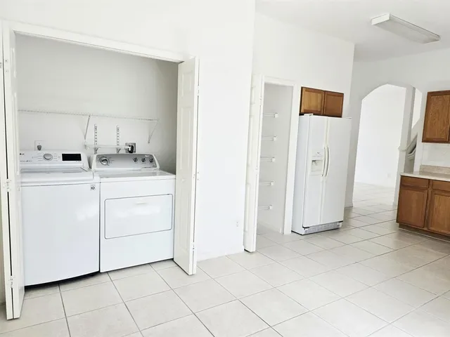 a utility room with cabinets washer and dryer
