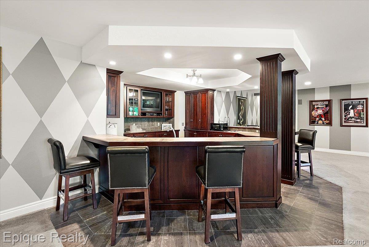 7662 Devins Ridge Clarkston, MI 48348 - Photo 73 of 81 Custom wet bar featuring rich wood cabinetry and a functional countertop
