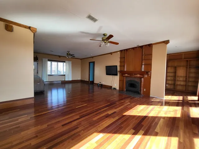a view of a living room and kitchen with wooden floor
