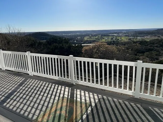 a view of a roof with wooden floor and fence