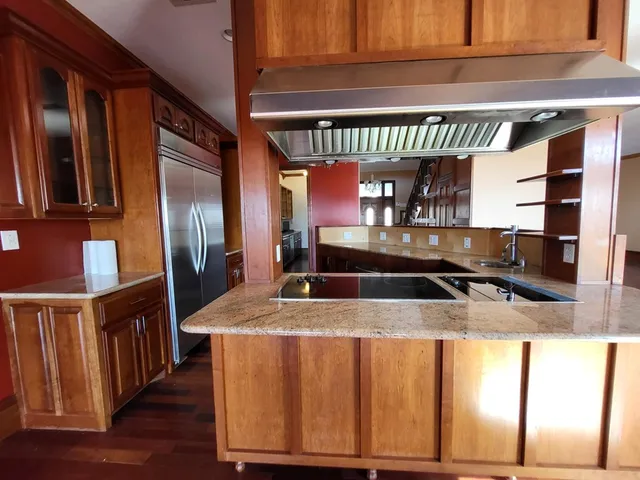 a kitchen with stainless steel appliances granite countertop a sink and a refrigerator
