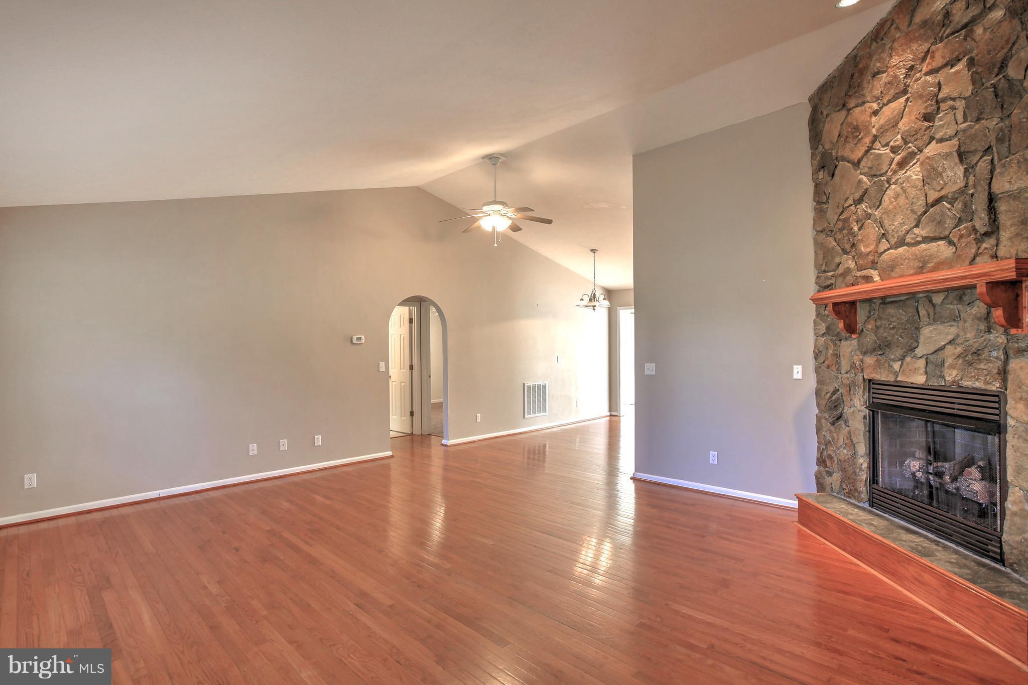 180 Spring Road Mineral, VA 23117 - Photo 5 of 22 a view of an empty room with wooden floor and a fireplace