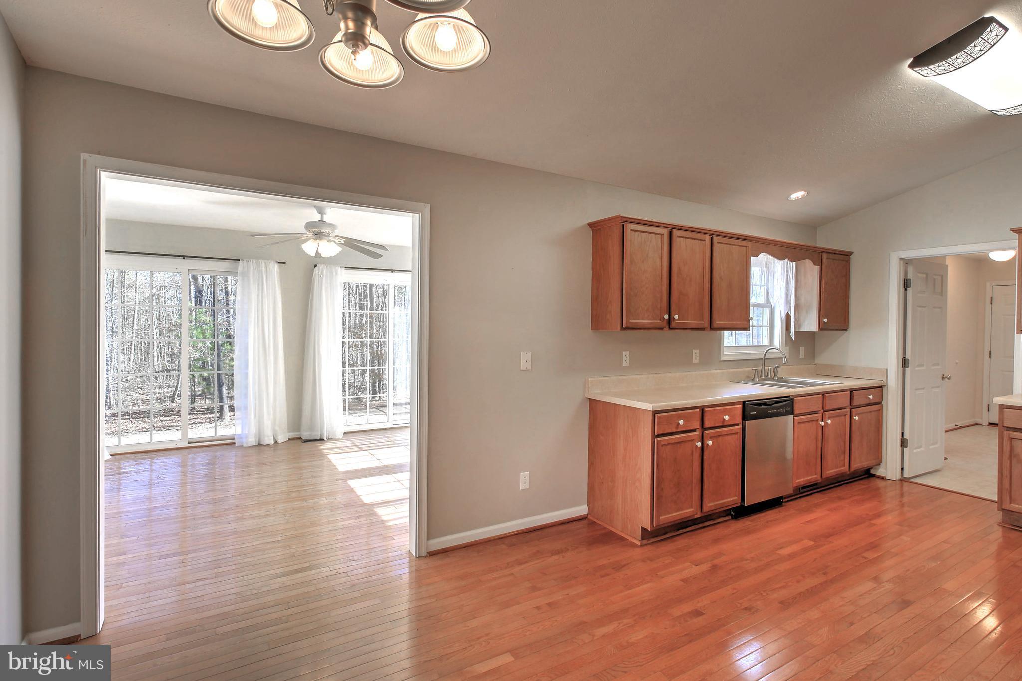 180 Spring Road Mineral, VA 23117 - Photo 7 of 22 a kitchen with stainless steel appliances granite countertop a stove a sink dishwasher and a refrigerator with wooden floor