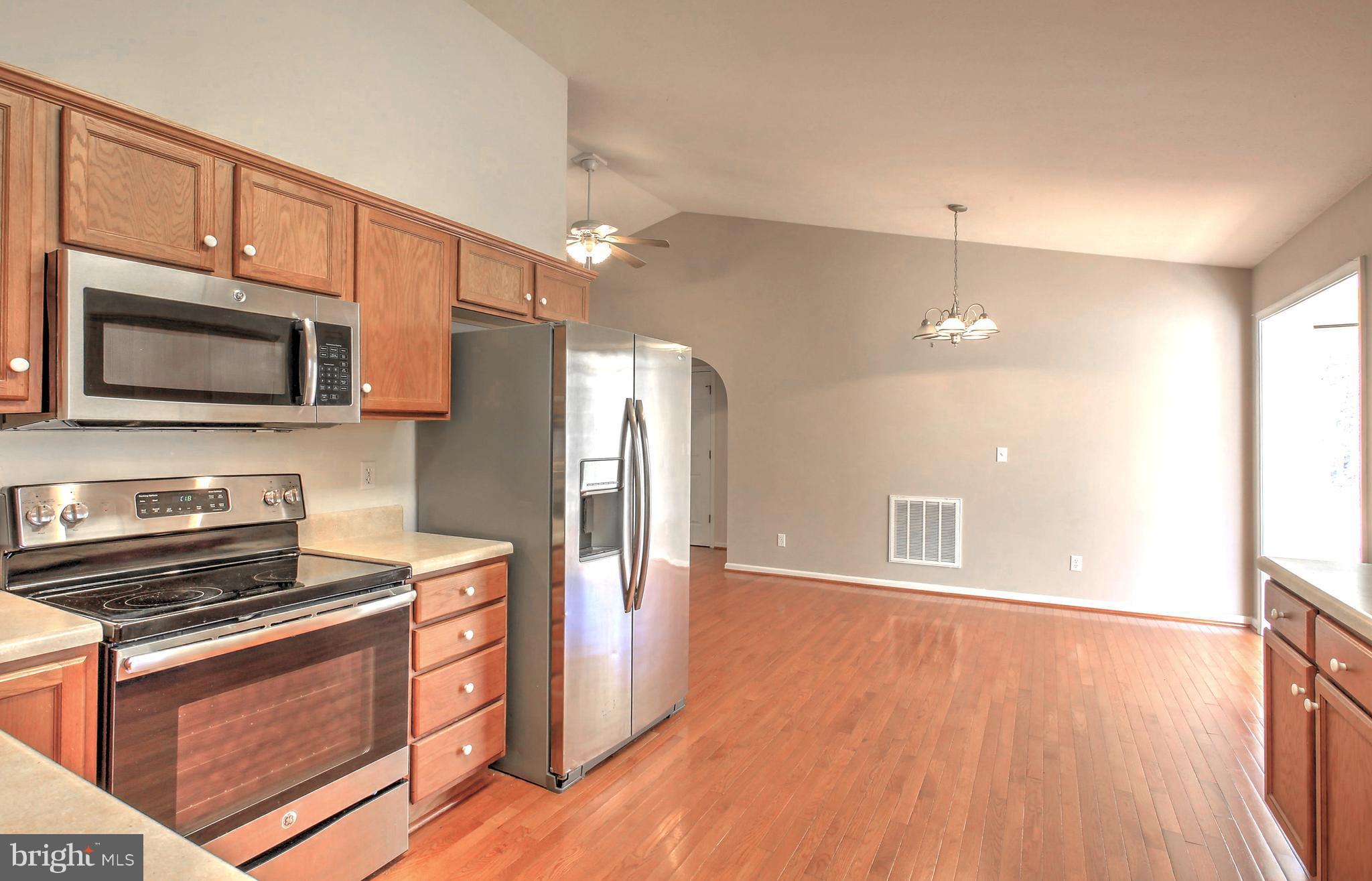 180 Spring Road Mineral, VA 23117 - Photo 8 of 22 a kitchen with stainless steel appliances kitchen island granite countertop a stove a refrigerator and a microwave