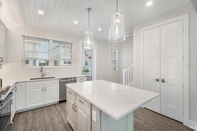 a kitchen with a sink a window and wooden floor