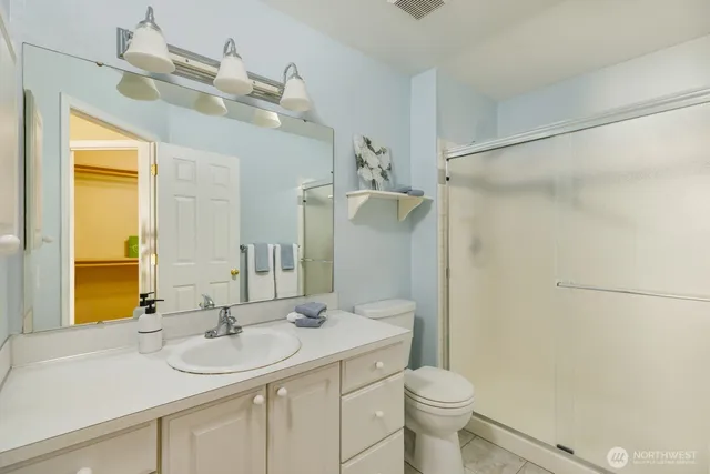 a bathroom with a sink vanity mirror and toilet