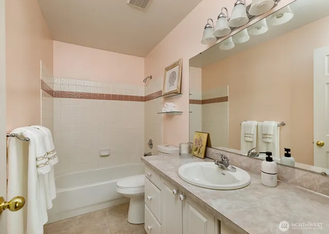 a bathroom with a granite countertop sink a toilet and shower