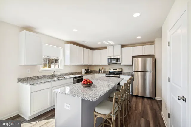 a kitchen with stainless steel appliances granite countertop a refrigerator sink and cabinets