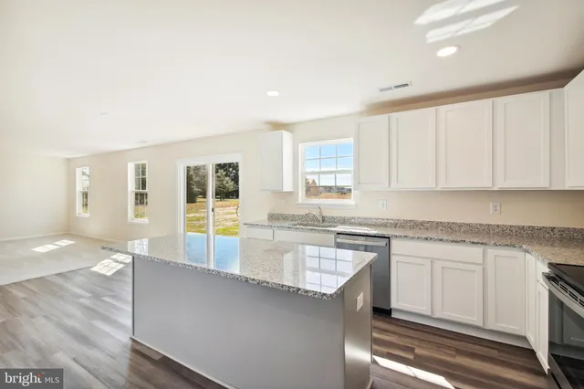 a large kitchen with granite countertop a stove a sink and a granite counter tops